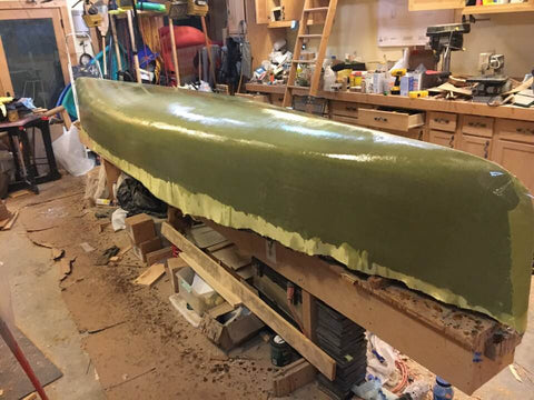 Greenish-coloured canoe hull made by combining black carbon fibre and yellow Kevlar