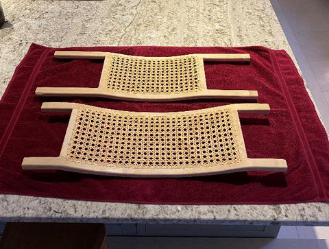 Caned canoe seats on a red towel