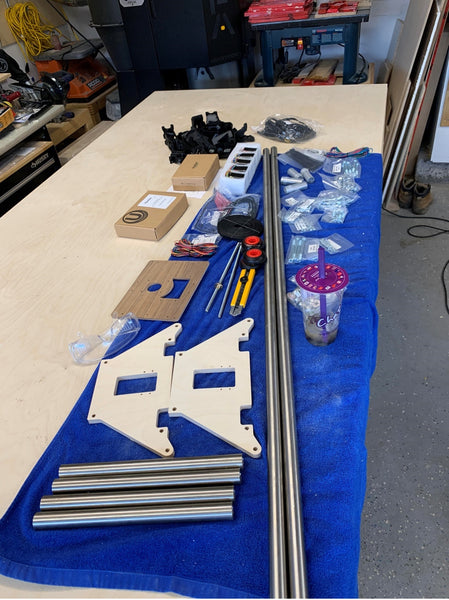 Parts for a mostly printed CNC machine laid out on a blue towel