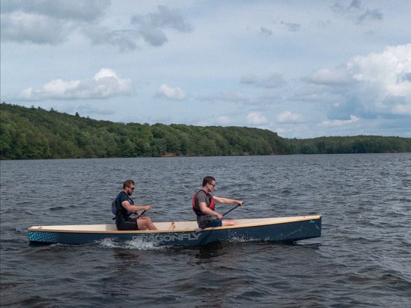 Two paddlers test a prototype of a dragonboat-style trainer boat on Upper Rideau Lake