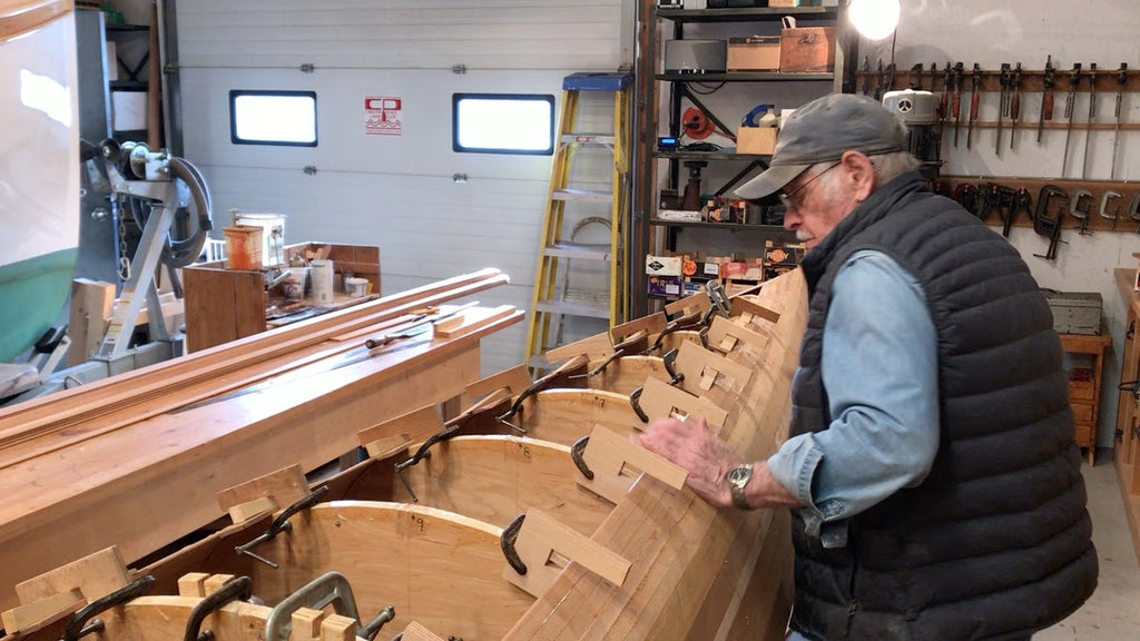 Ted Moores works on planking the hull of an unfinished C4 racing canoe