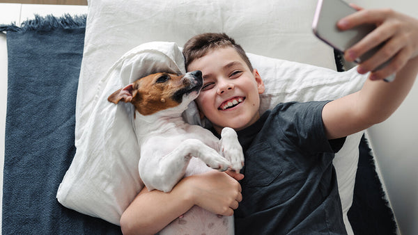 Boy growing up with his dog taking a selfie