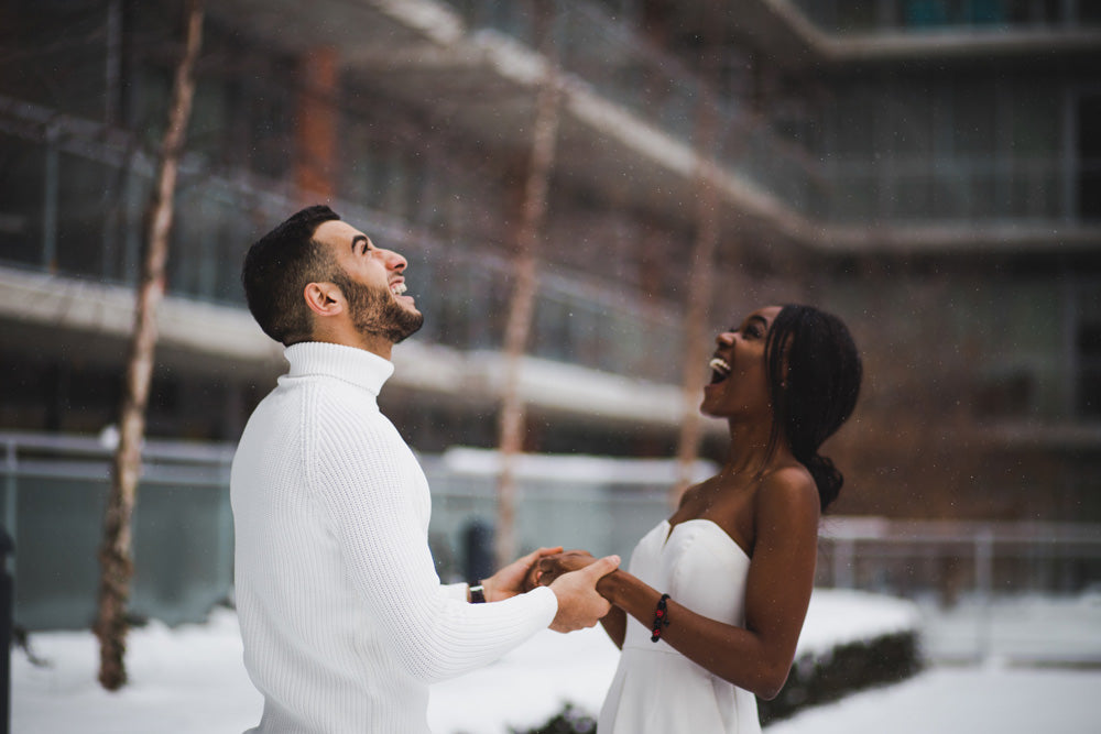man and woman smiling at winter snow