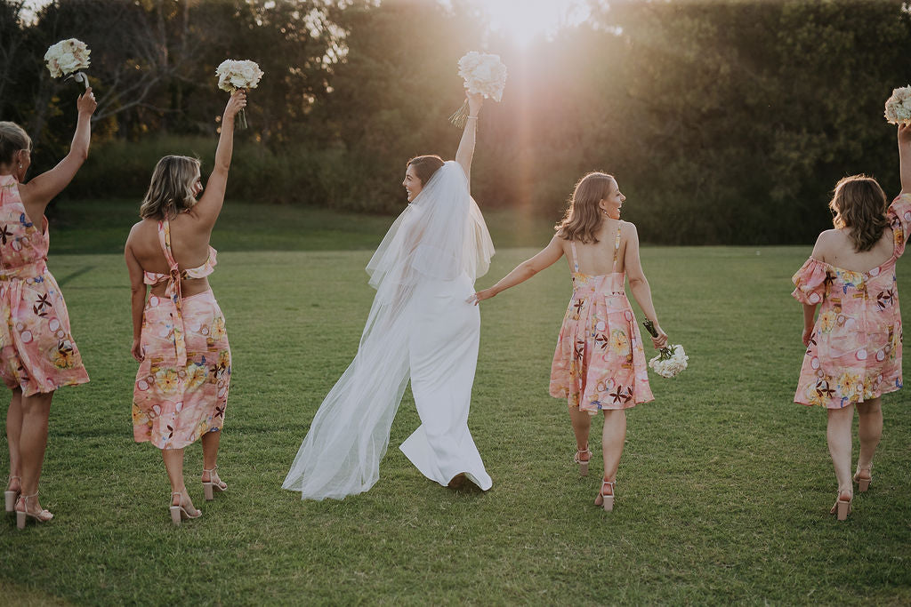 modern bride and bridesmaids wearing custom made printed linen dresses with floral bouquet in hand