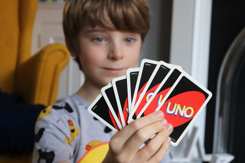 A boy holds uno, a top 10 family game