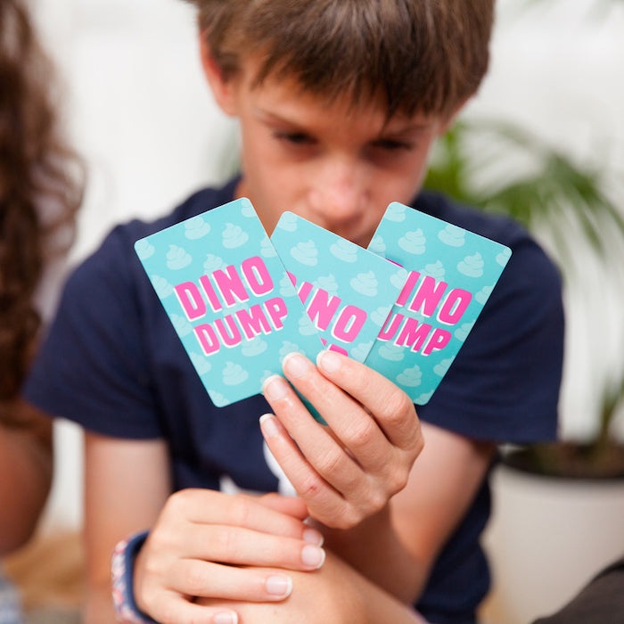 A person focussing intently on a deck of Dino Dump cards