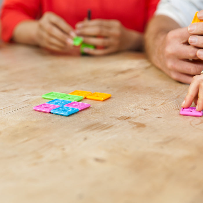 People assembling new OK Play tiles on the table