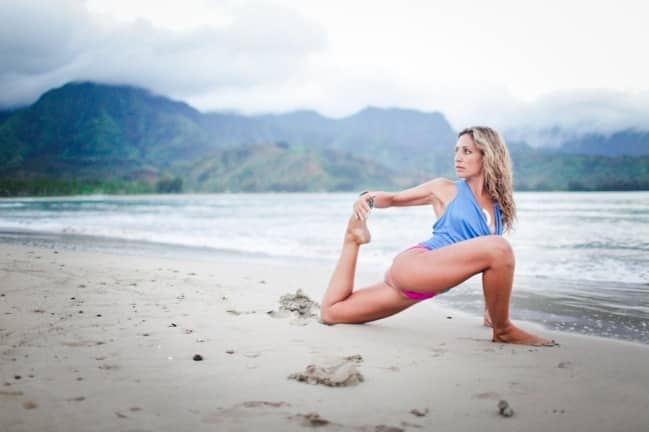 Woman stretching her leg on the beach