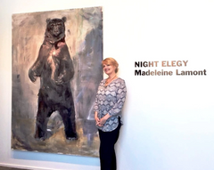 Madeleine Lamont, standing beside a large painting of a bear