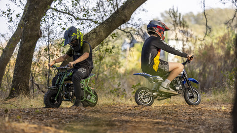 Two kids are riding the FRP gas mini dirt bike on the off-road area.