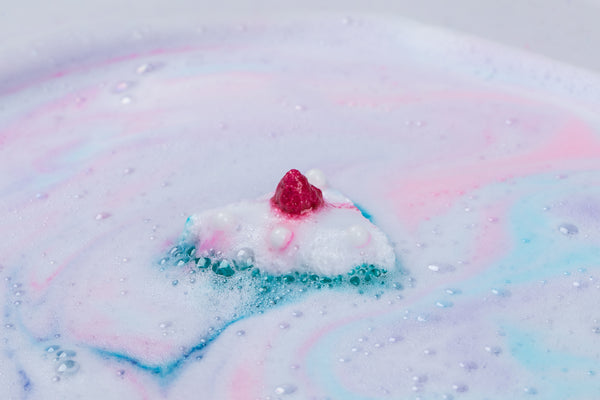 a cake shaped bath bomb effervescing in water 