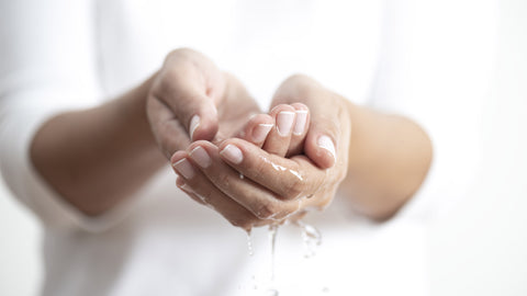 a person washing their hands at a sink