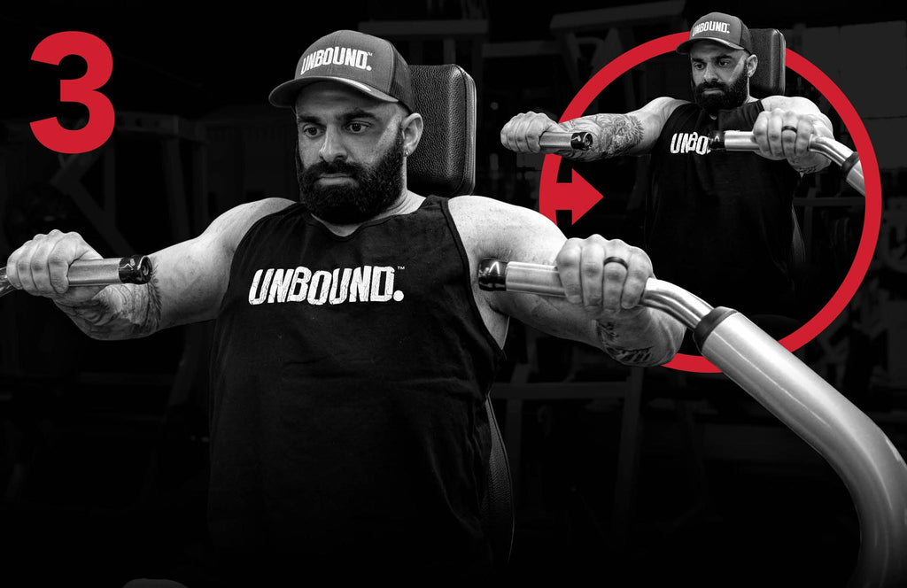 Steven Mitropoulous doing a flat machine bench press while wearing an Unbound Spplements t-shirt