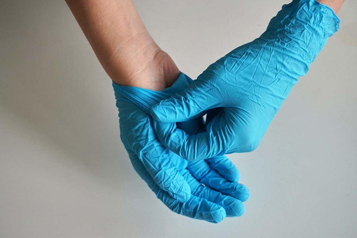 Person taking off blue gloves