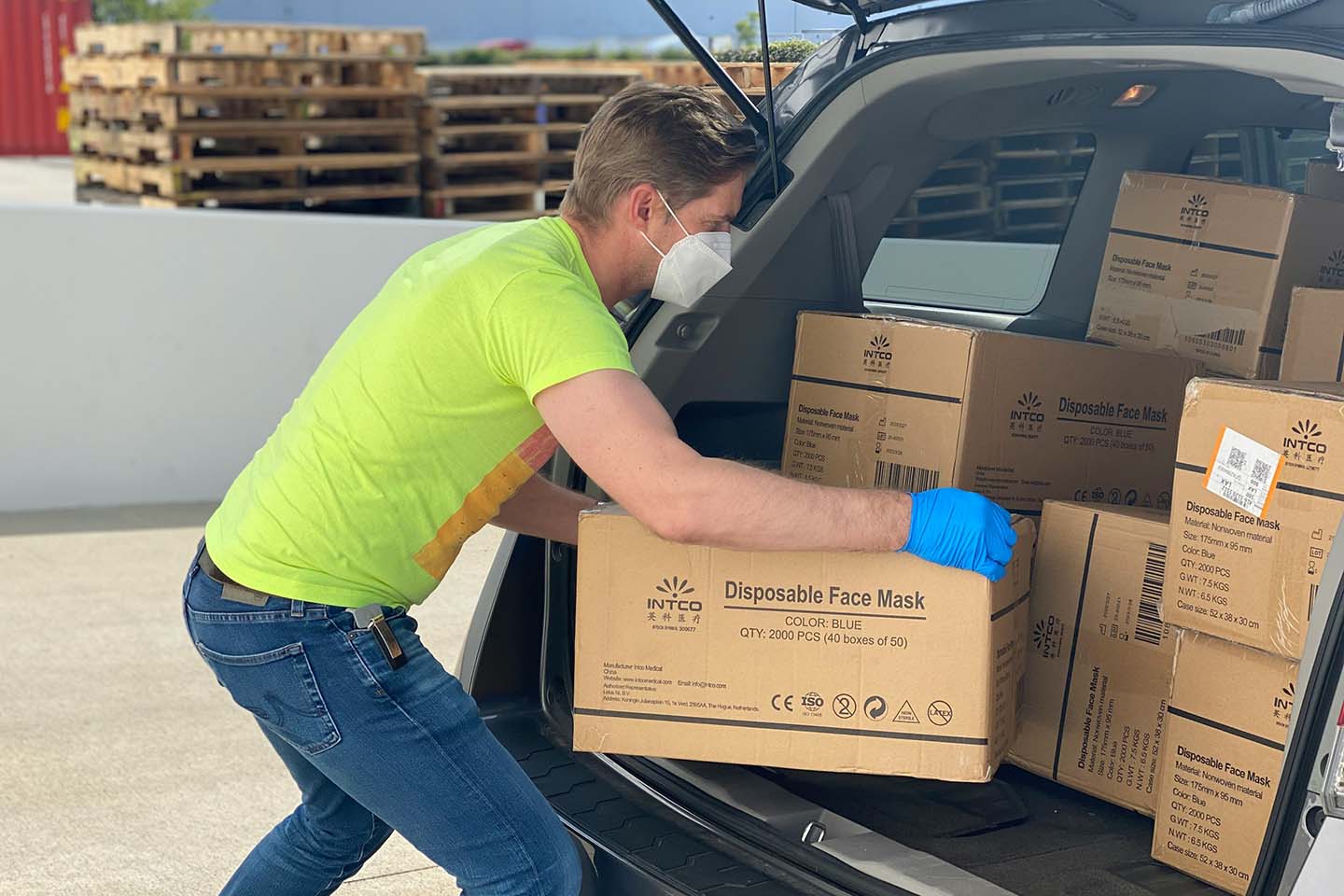 man wearing disposable gloves while getting a brown box