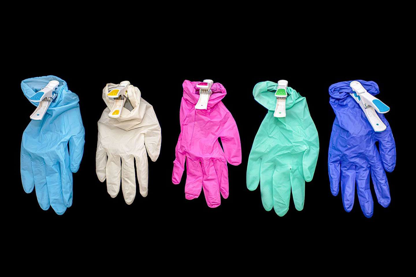5 colored surgical gloves against black background