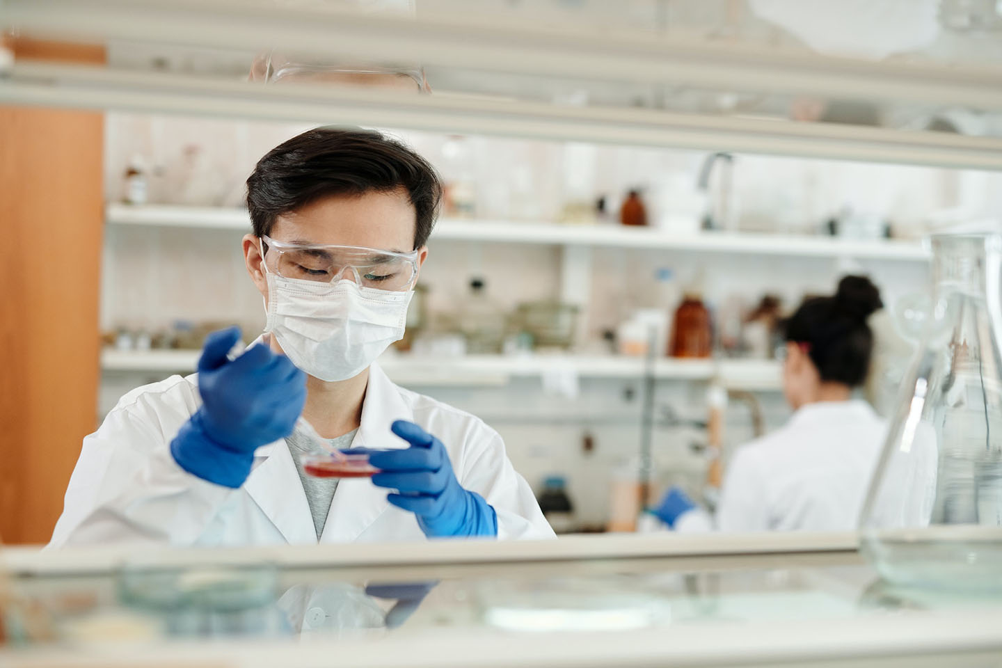 a professional doing a sample test in the laboratory while wearing protective gloves