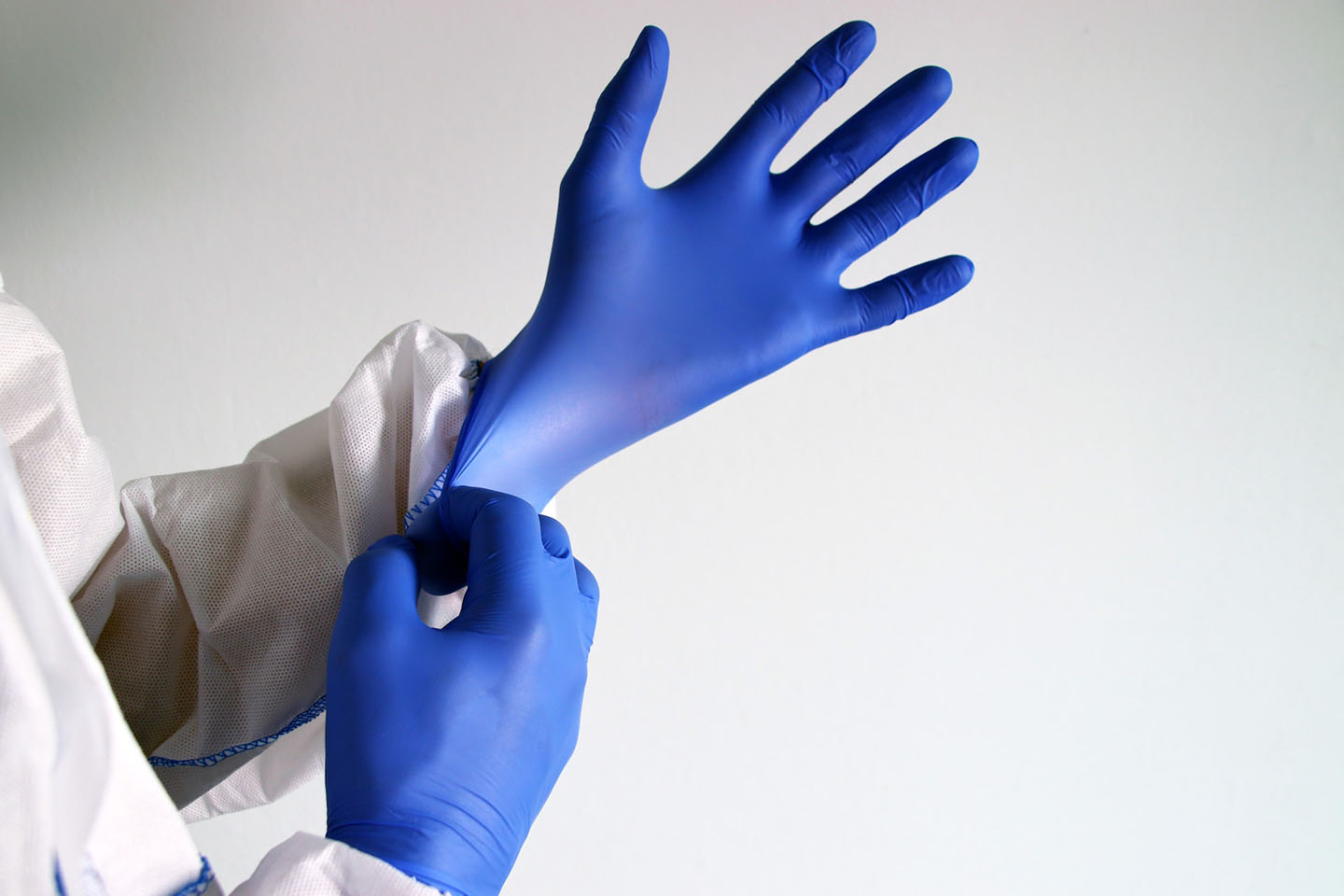 medical staff donning a blue-colored nitrile gloves