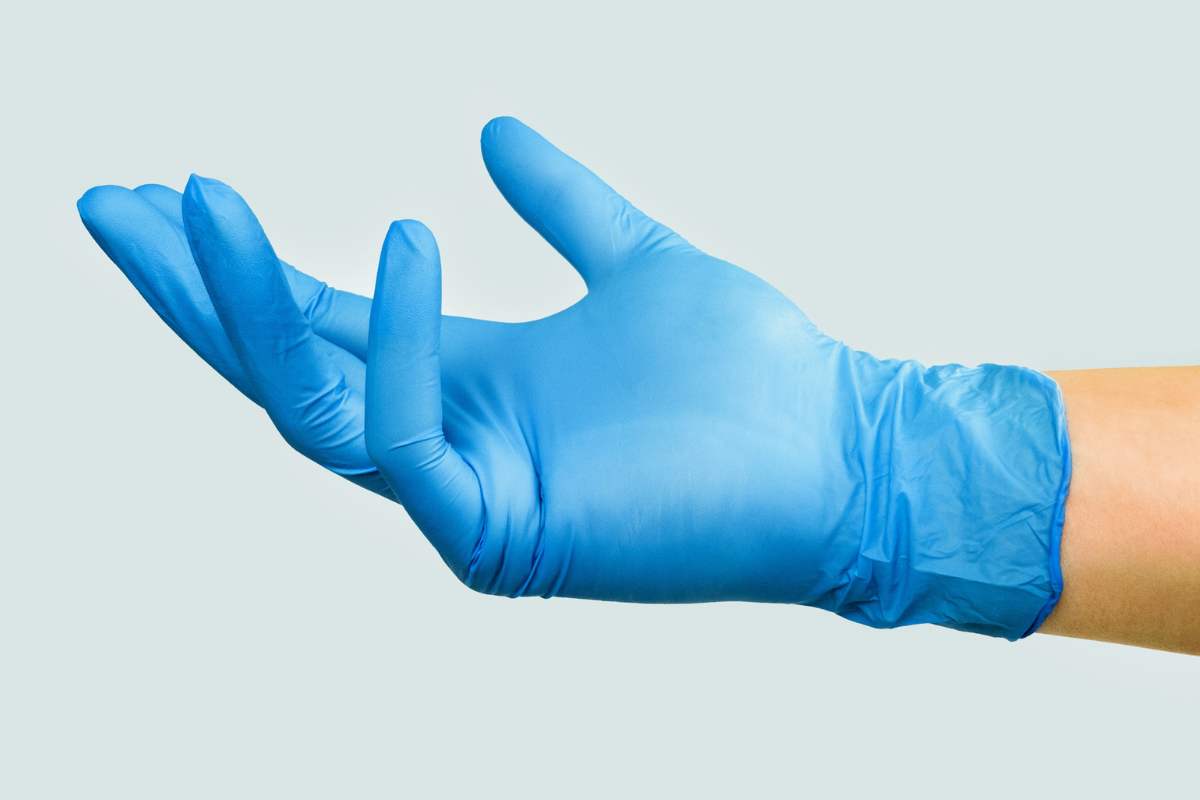 a hand in disposable medical gloves