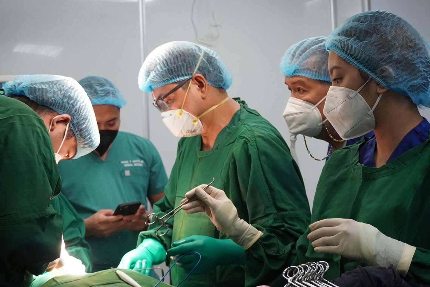 A surgical team in the middle of a surgery in the operating room.