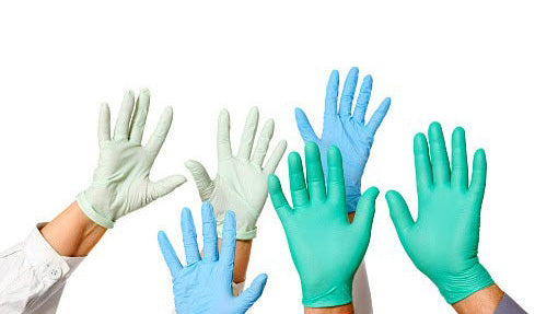 Many hands waving wearing a variety of different colored disposable gloves.