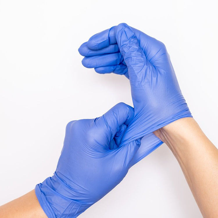 Two hands wearing disposable latex gloves. The left hand is stretching the cuff of the right hand.