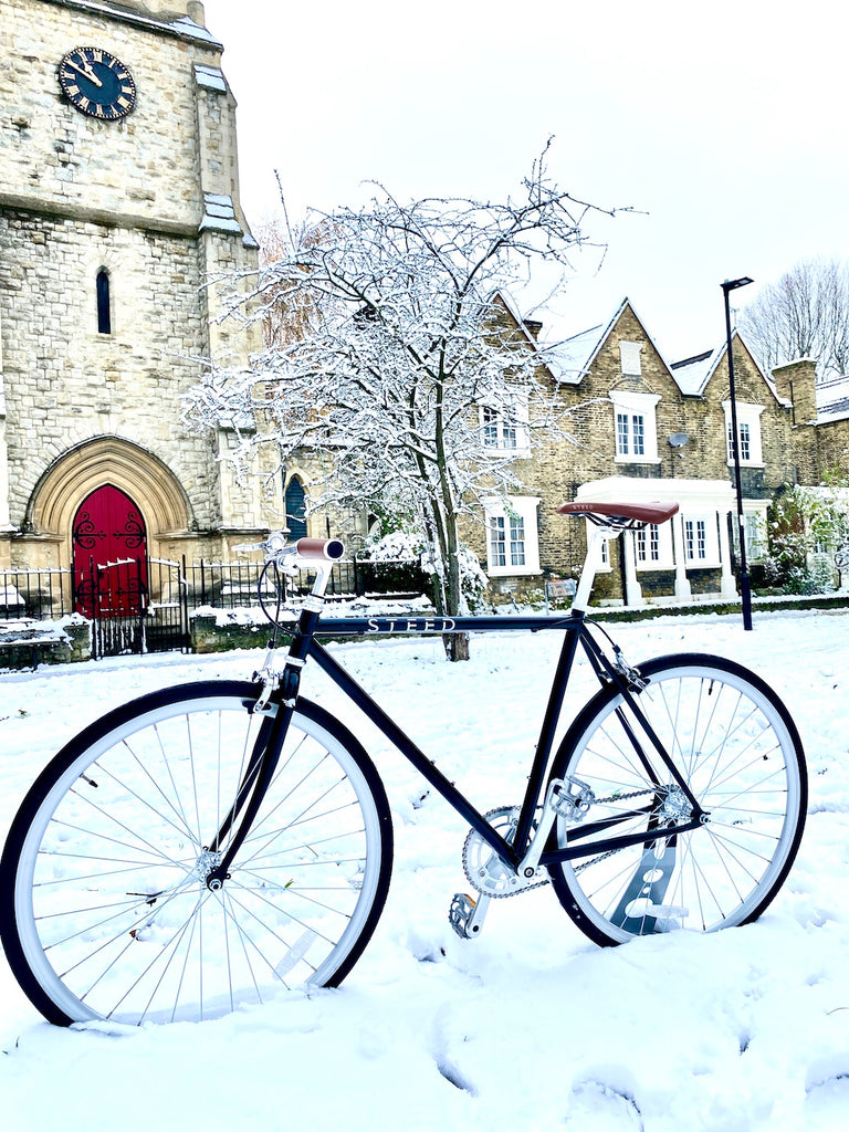 Black Steed Bike in snow in front of church