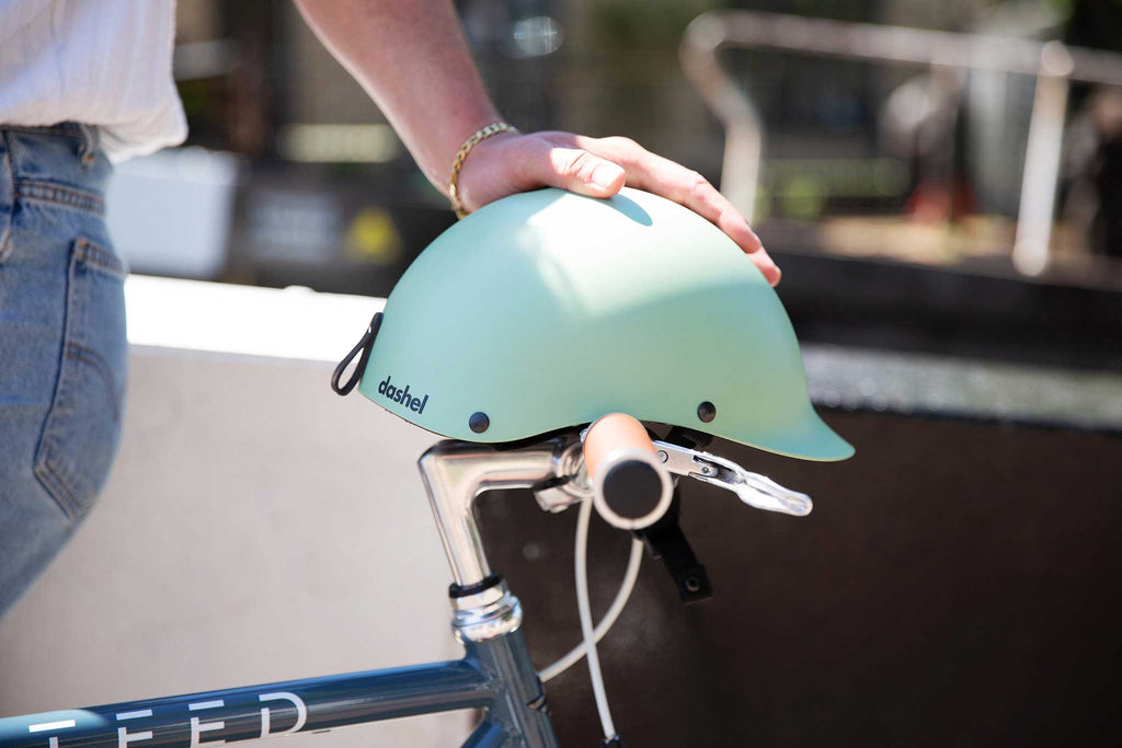 Sage Green Dashel helmet resting on Steed Bike handlebar