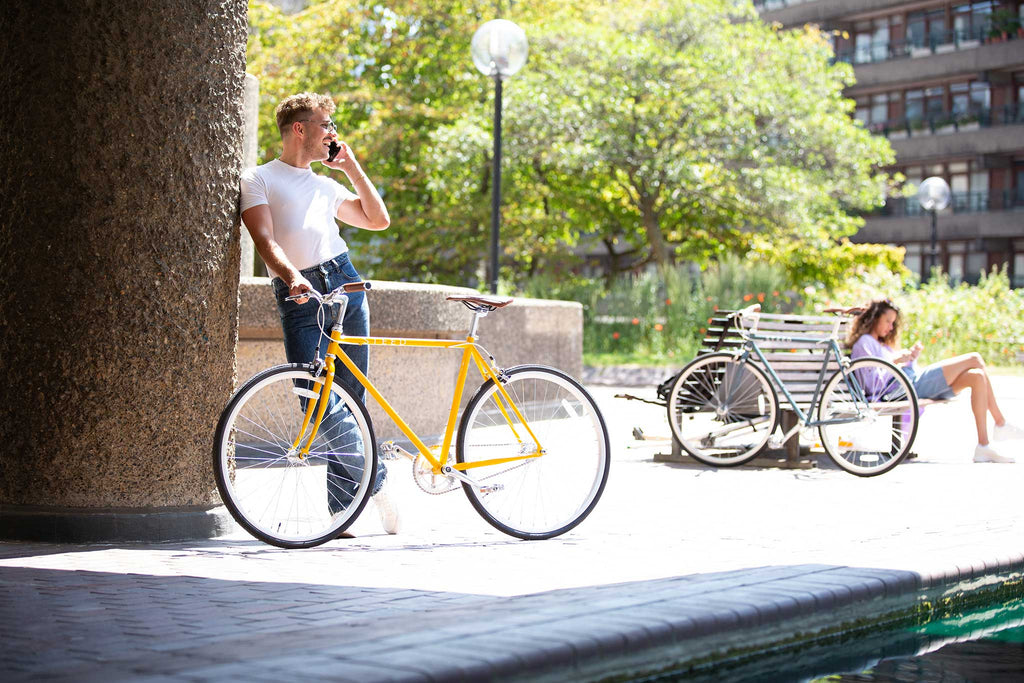 boy on phone holding yellow Steed Bike