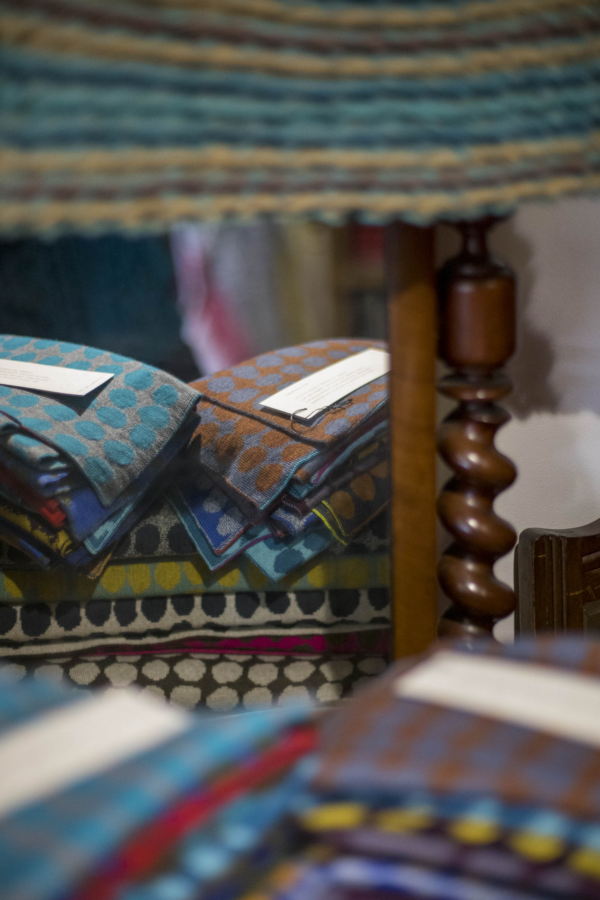 Stacks of contemporary knitwear on antique furniture in the Nielanell studio shop, Shetland