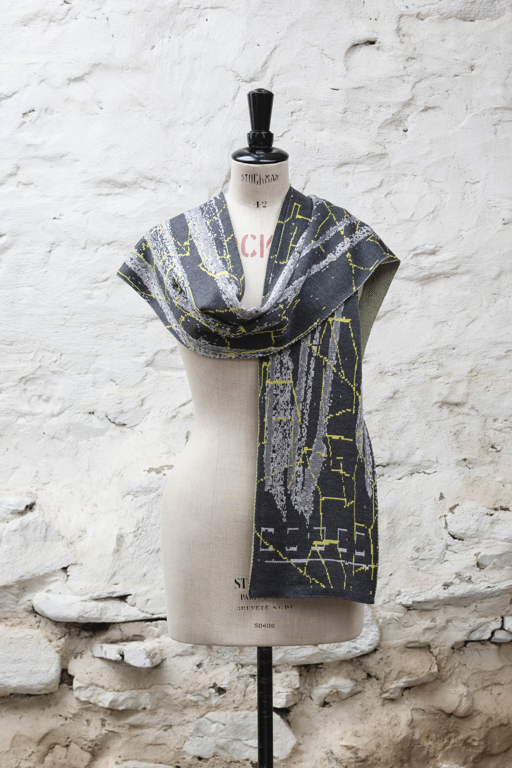 Contemporary Scottish knitted scarf with abstract pattern in greys with fluoro yellow highlights