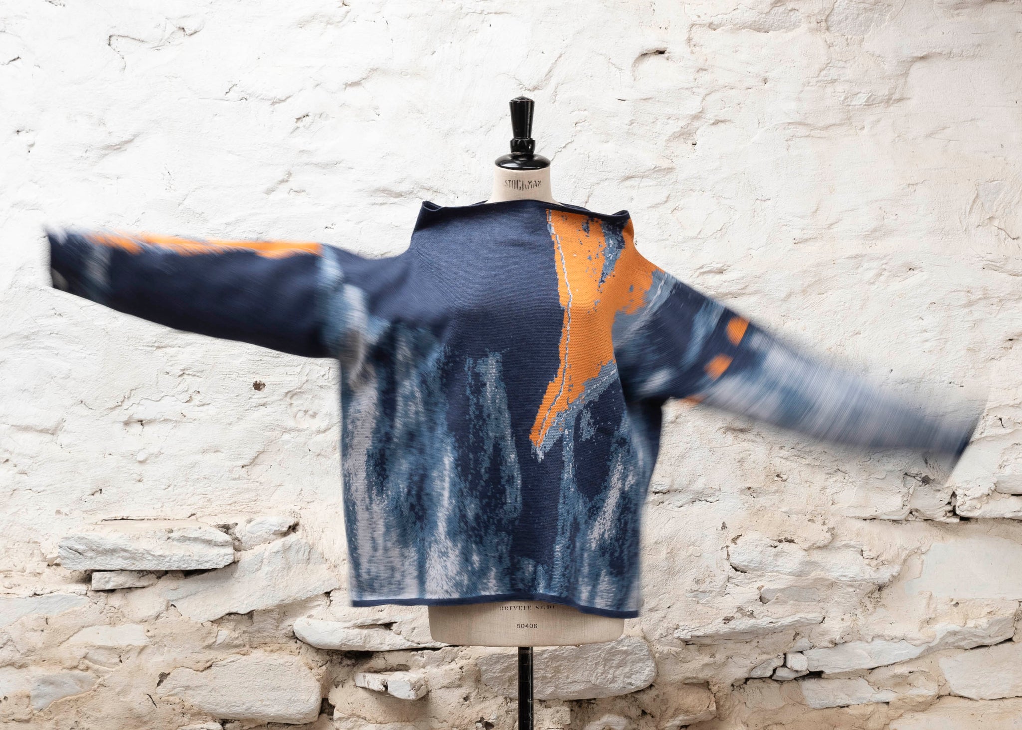 Modern scottish knitwear made in Shetland - a jumper with an abstract design in blues and with orange highlights. Statement knitwear