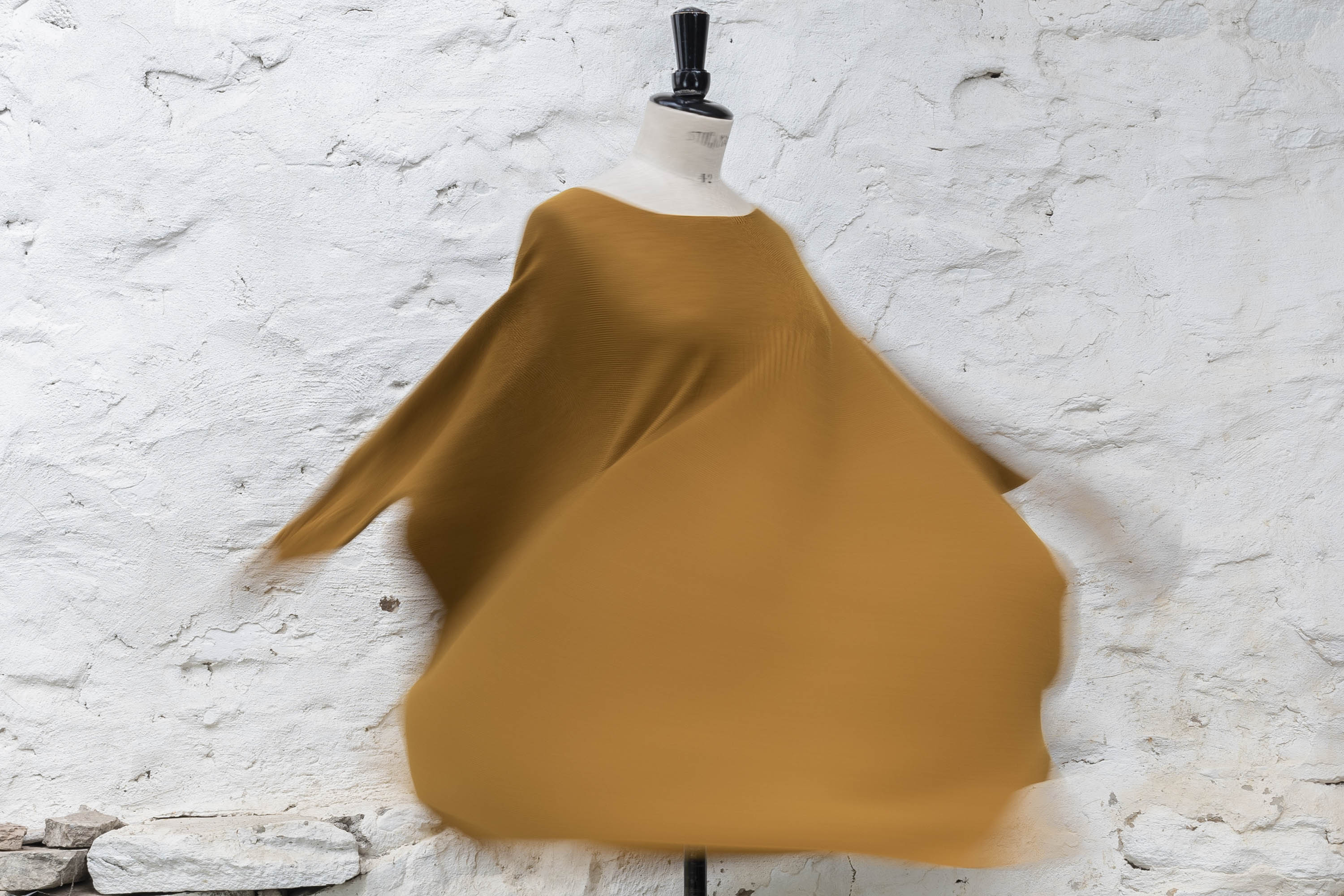 Lightweight contemporary merino sweater made in Scotland. Ochre yellow, on a mannequin being spun to show relaxed shape