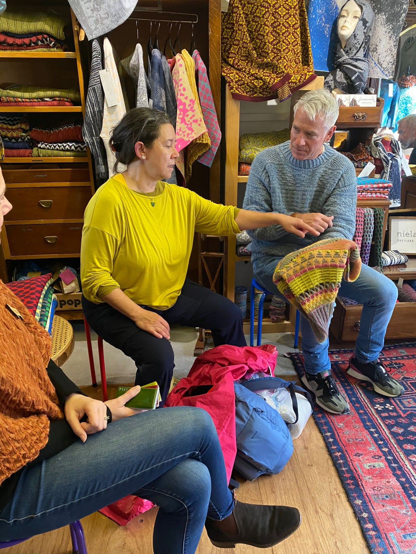 In the Nielanell knitwear studio, Shetland. A lana del pascolo shawl is discussed by visitors.