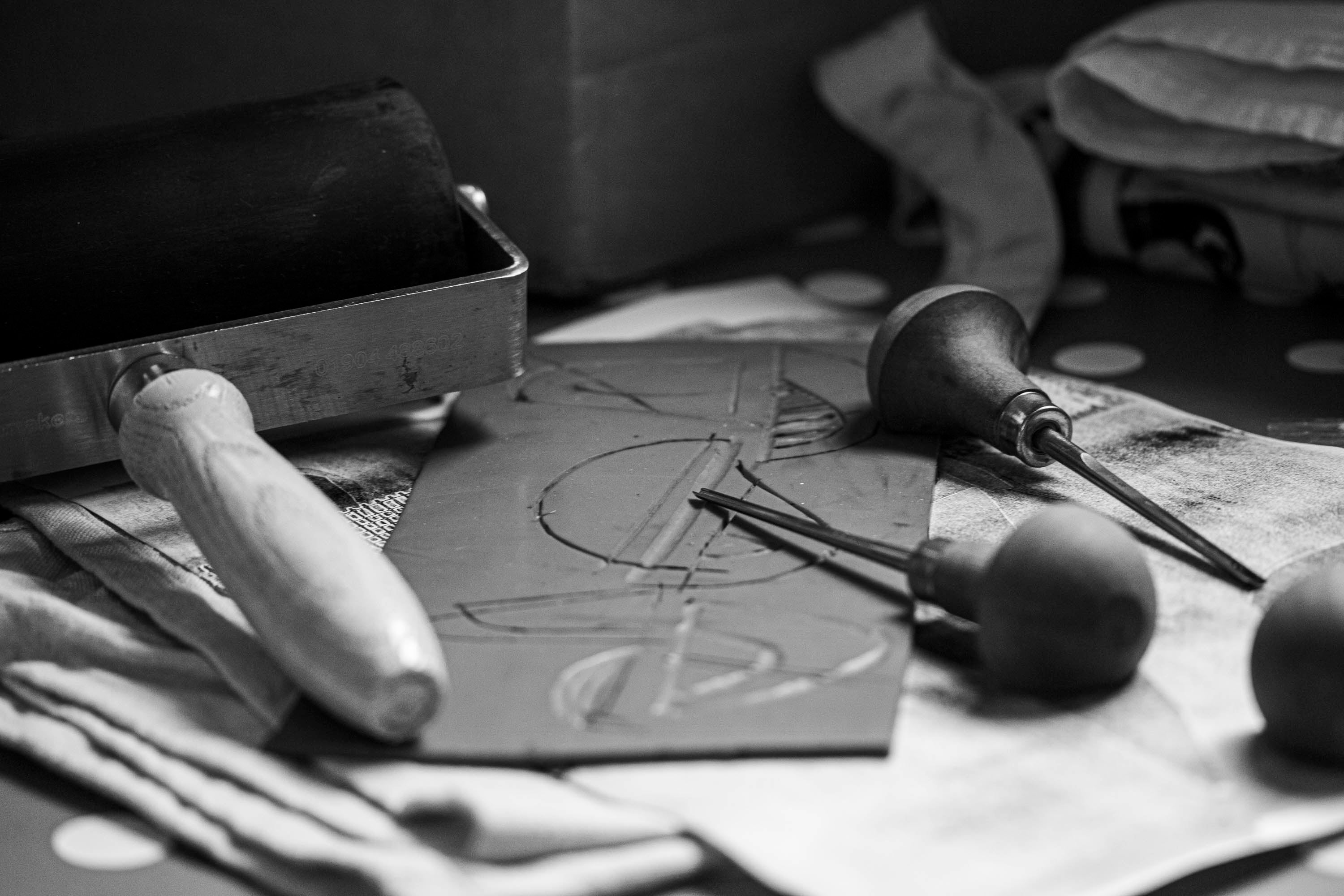 Lino cut in process. Lino, with abstract motif, cutting tools, roller.