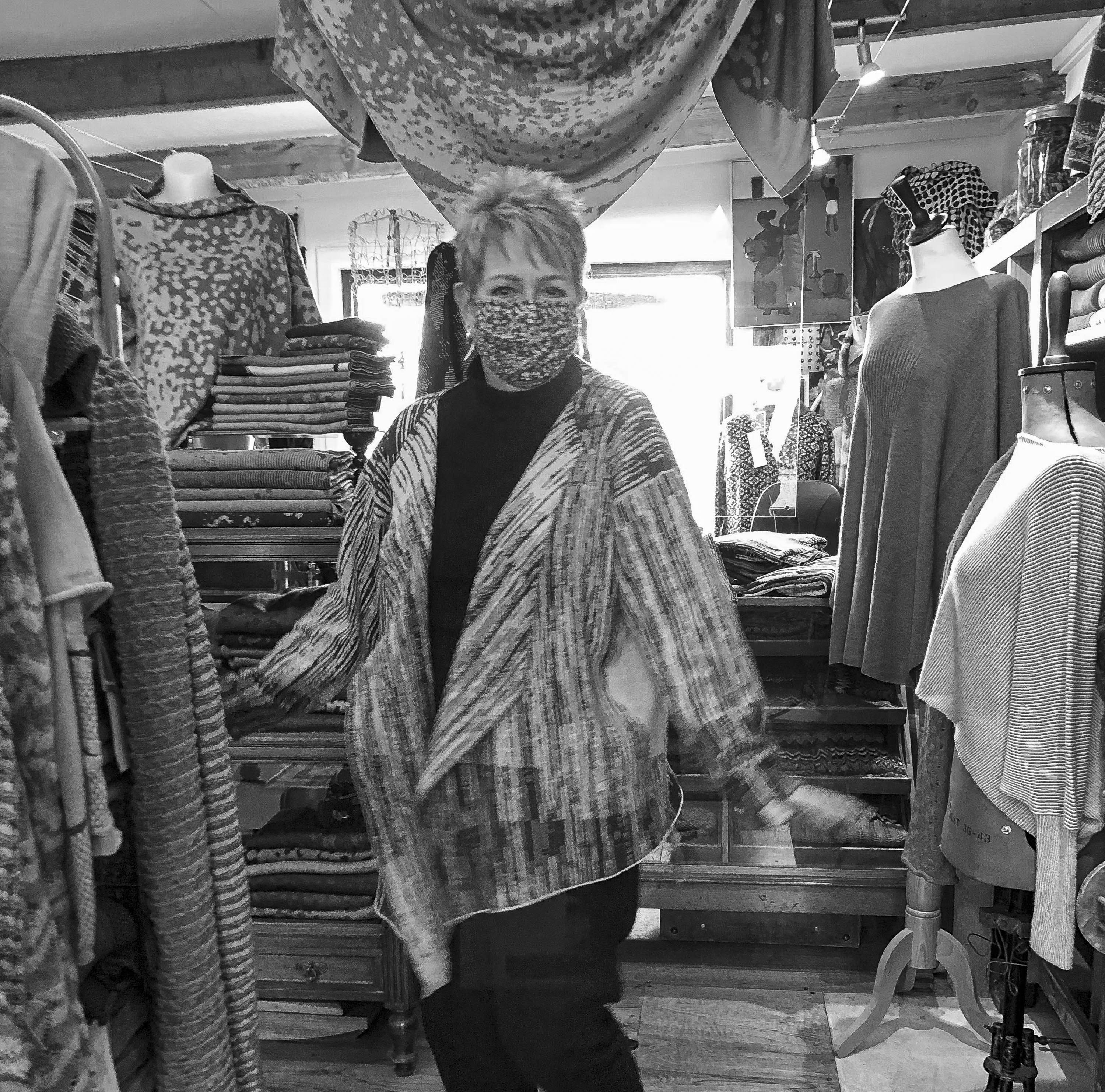 In the Nielanell knitwear studio, Hoswick, a woman wears an abstract, linear pattern knitted jacket. contemporary in style and with wide lapels