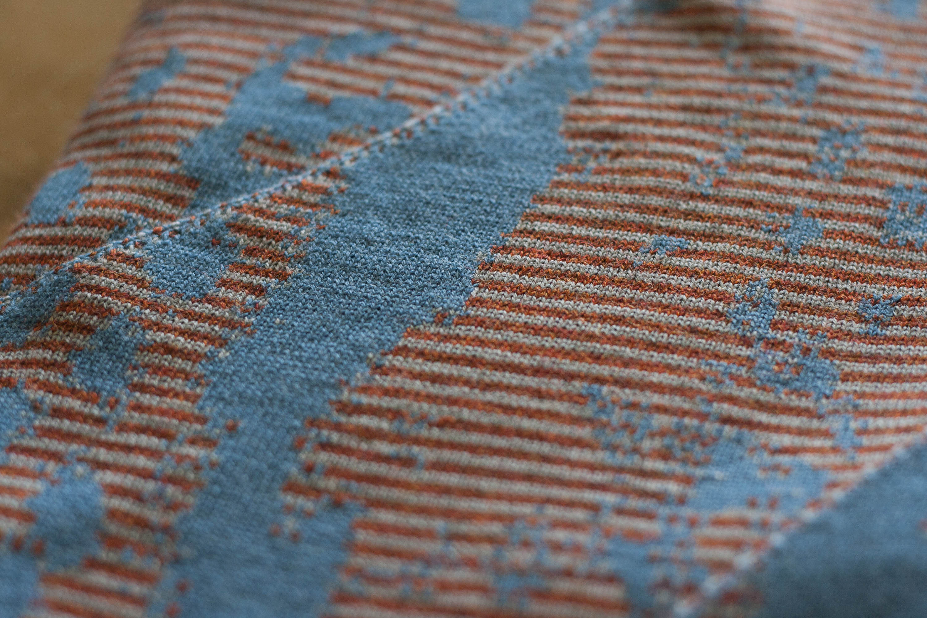 Detail of striped Marlet textile in blues and rusts. Mottled abstract textile design