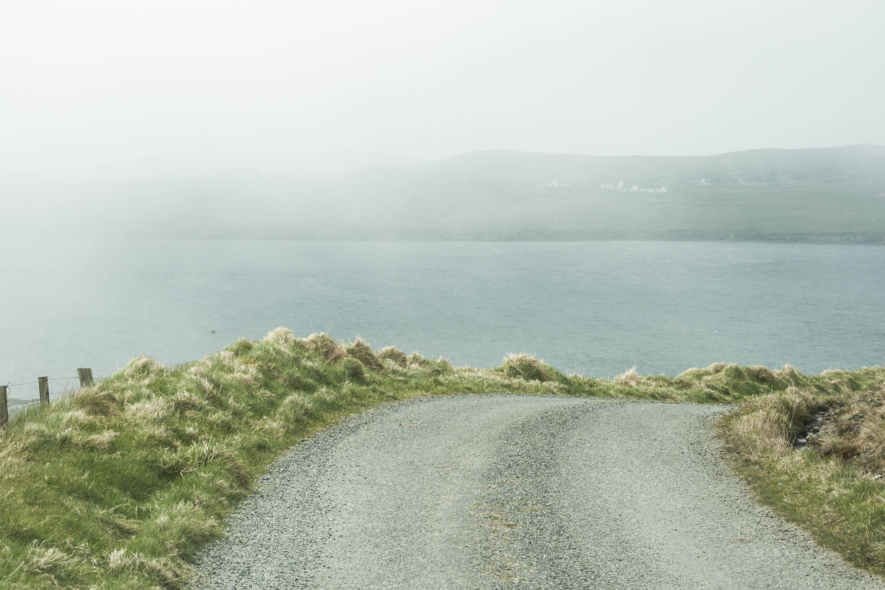 Haar in Shetland hanging over the sea above a steep road