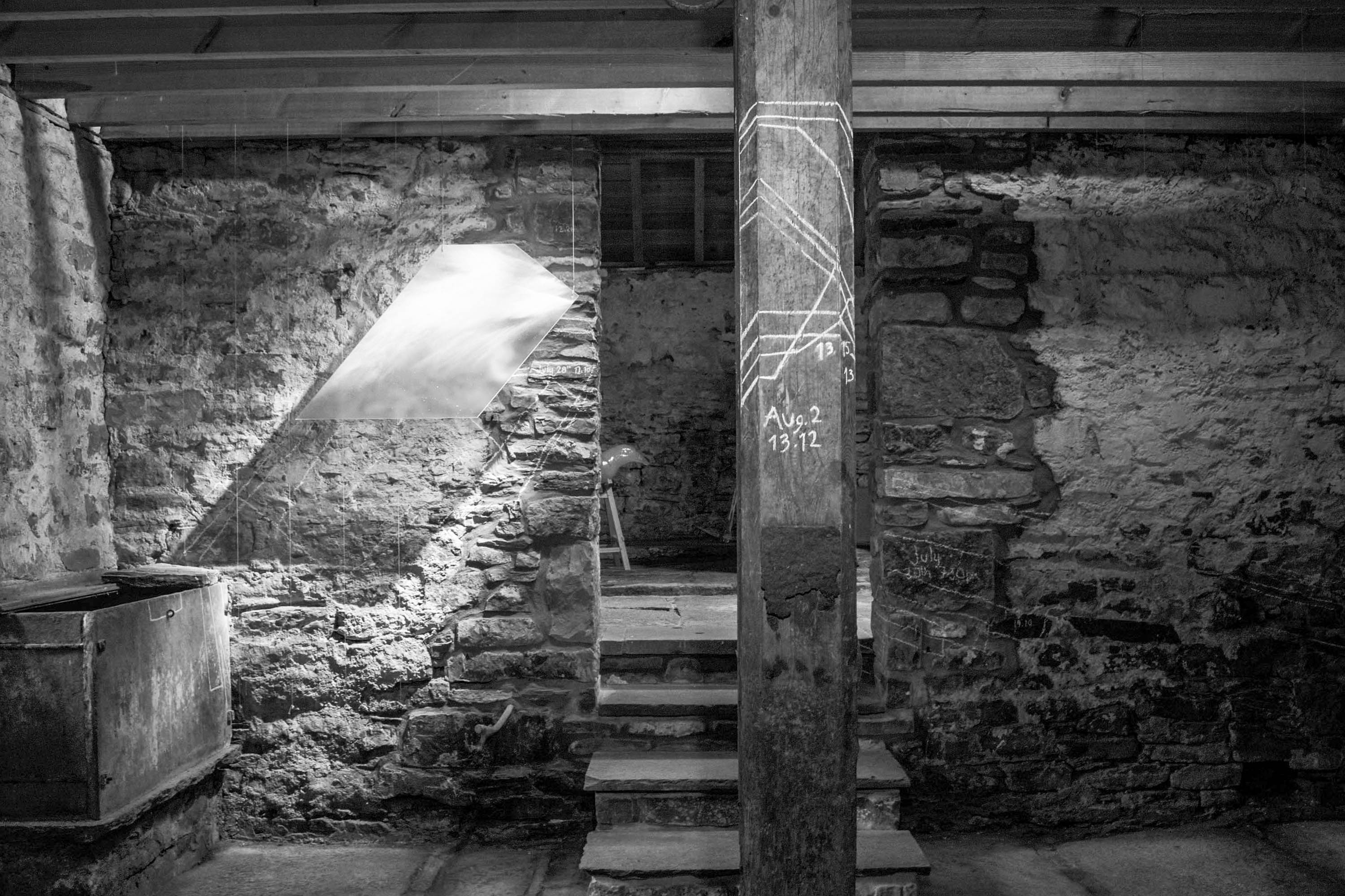 Interior of Scottish traditional Byre, with glass installation by artist Karlyn Sutherland. Panels of glass are hung to illustrate the shape of shards of light