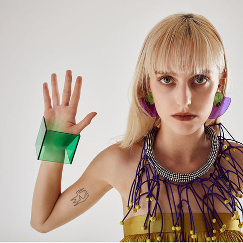 girl posing with green plexiglass bracelet cuff and purple plexiglass earrings