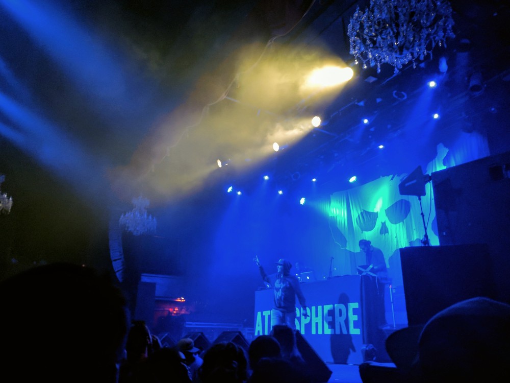 The artist Atmosphere on a blue lit stage