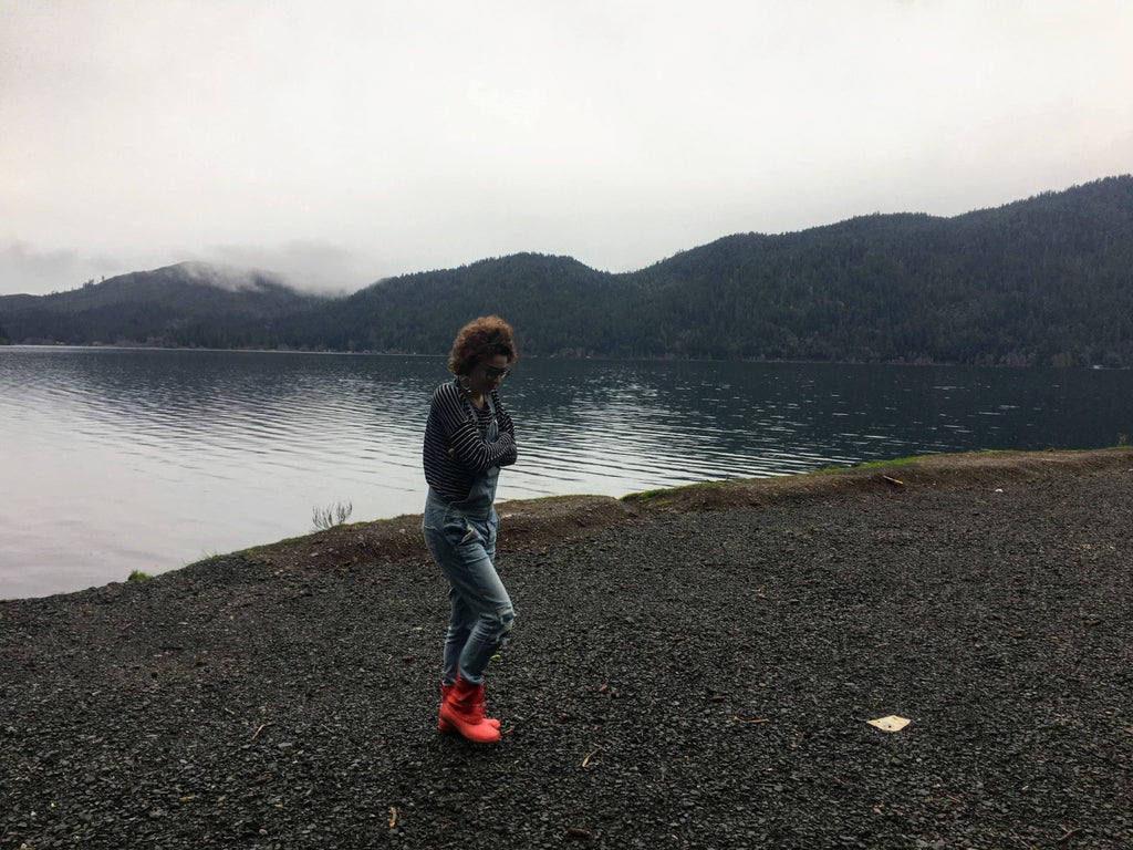 The artist walks along a gloomy beach shore near a lake on a cloudy day