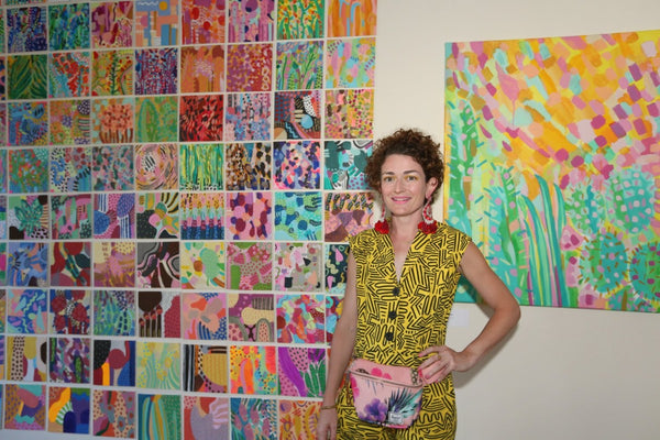 The artist in front of 100 mini paintings