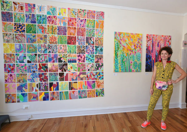 The artist in front of her paintings.