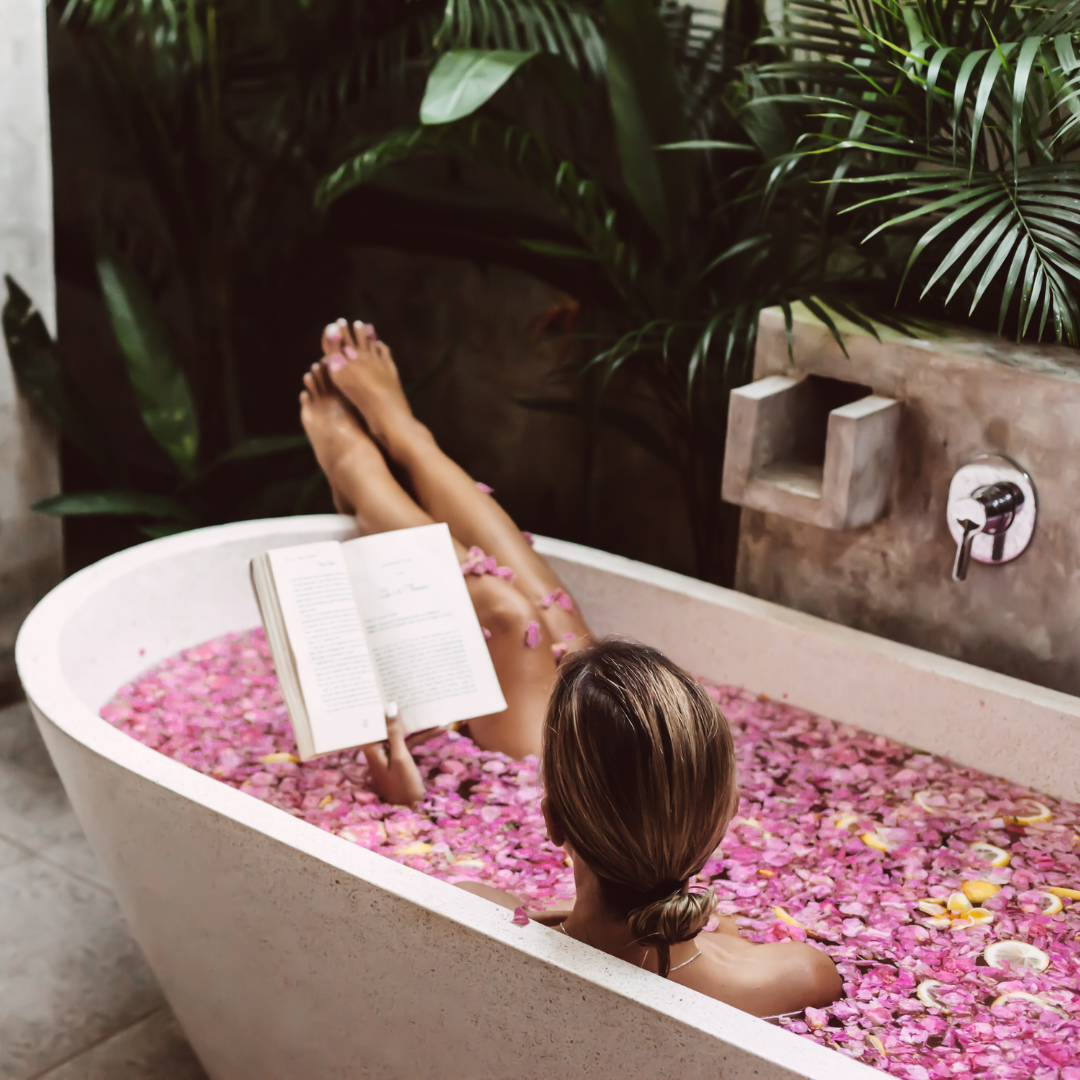 Rose Geranium Oil, floral bath with book in outoors