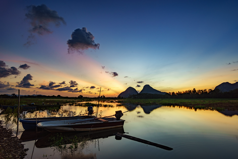 Beautiful majestic sunrise by the lakeside with fishing boats