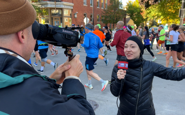 Person filming newscast with smartphone