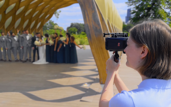 Person filming a wedding party outdoors with their smartphone.