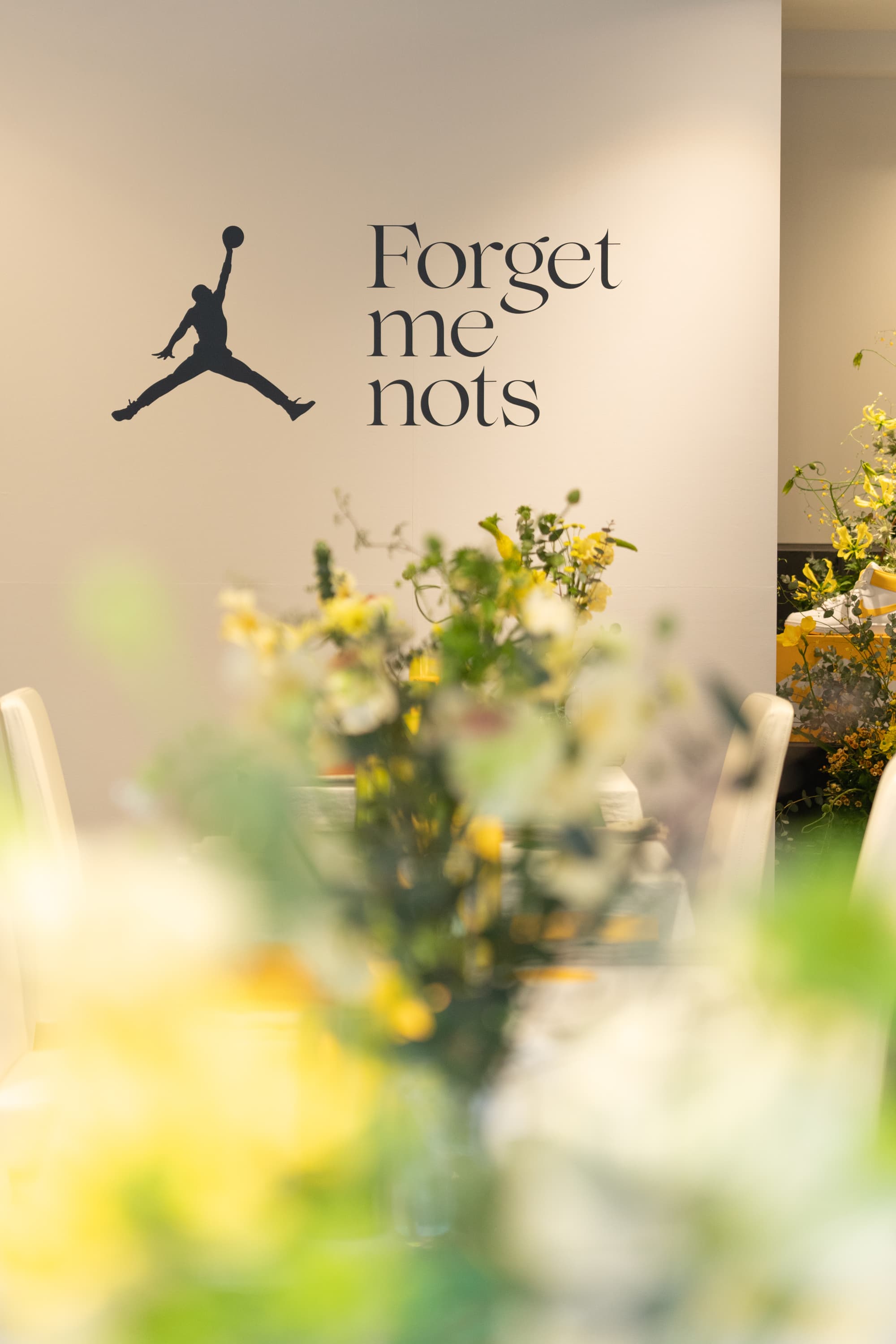 花々で装飾された店内の壁に設置されたジャンプマンとForget-me-notsのロゴ