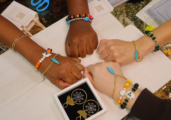 Teniquesters showing off their handmade bracelets at Halloween jewelry making party.